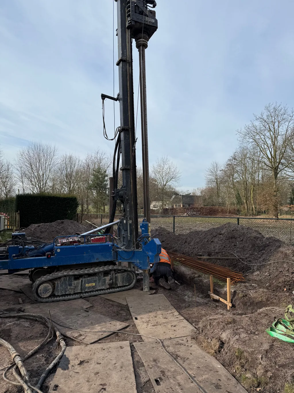 Boorstelling voor casing draaipalen op rijplaten, met wapeningsstaal klaar om in de palen te plaatsen