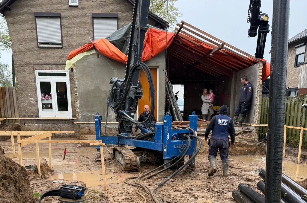 Boorstelling van KFT plaatst schroefinjectiepalen in de bouwput van een uitbouw aan een bakstenen woning