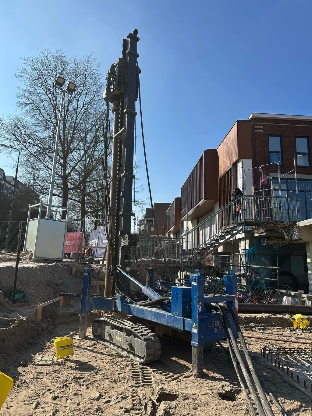 Blauwe LBT 2.5 op rupsonderstel boort casing draaipalen met groutinjectie in een bouwput in Bilthoven