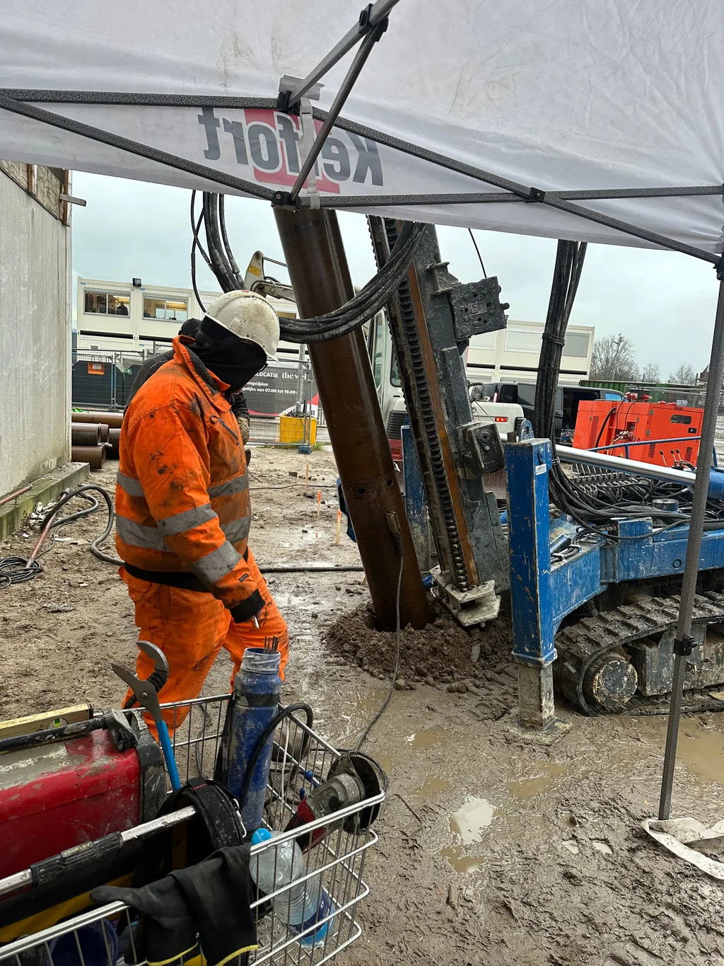 Medewerker in oranje werkkleding bij een schorende casing draaipaal met groutinjectie in Nieuwegein
