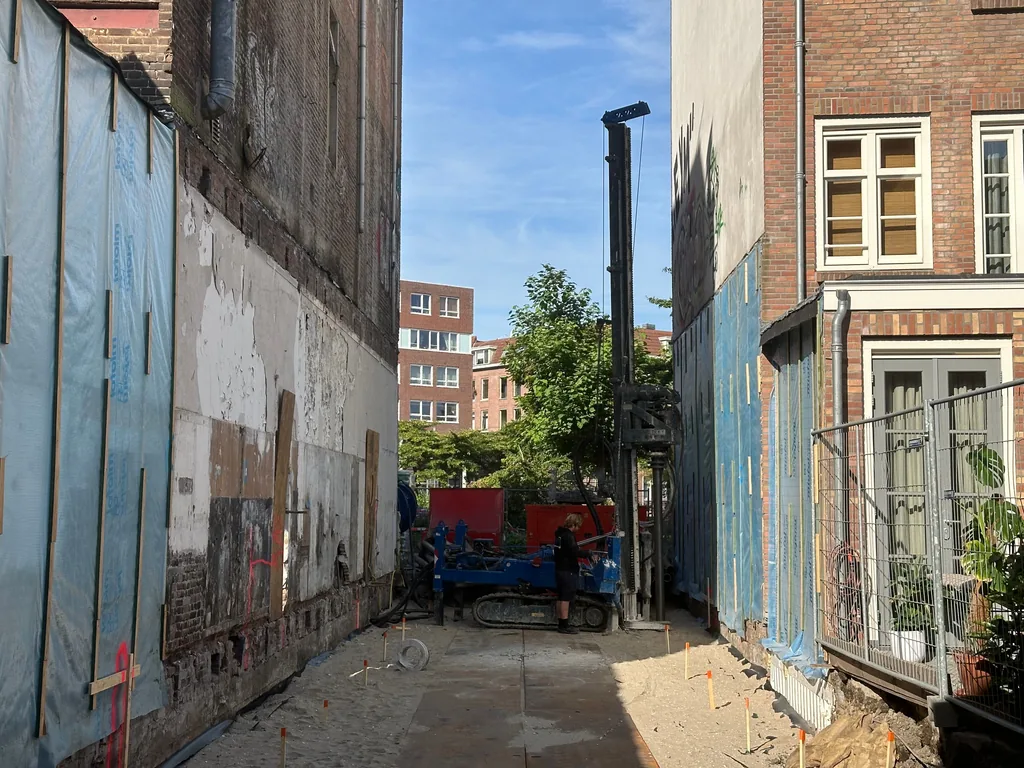 Boorstelling voor casing draaipalen achter in een smalle bouwkavel tussen bestaande woningen in Rotterdam
