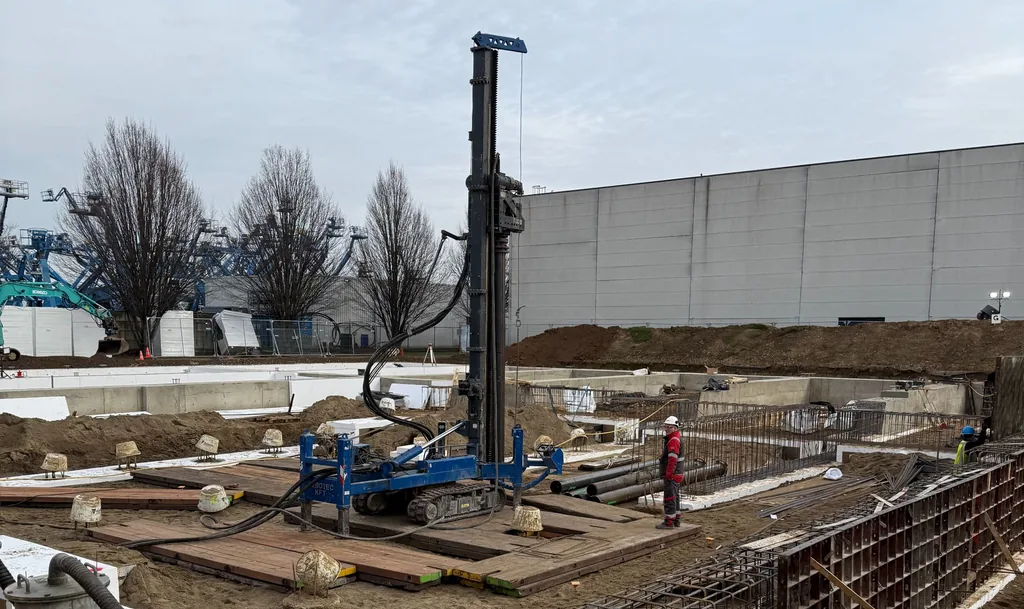 Boorstelling voor casing draaipalen op houten rijplaten op een bouwterrein in Sittard