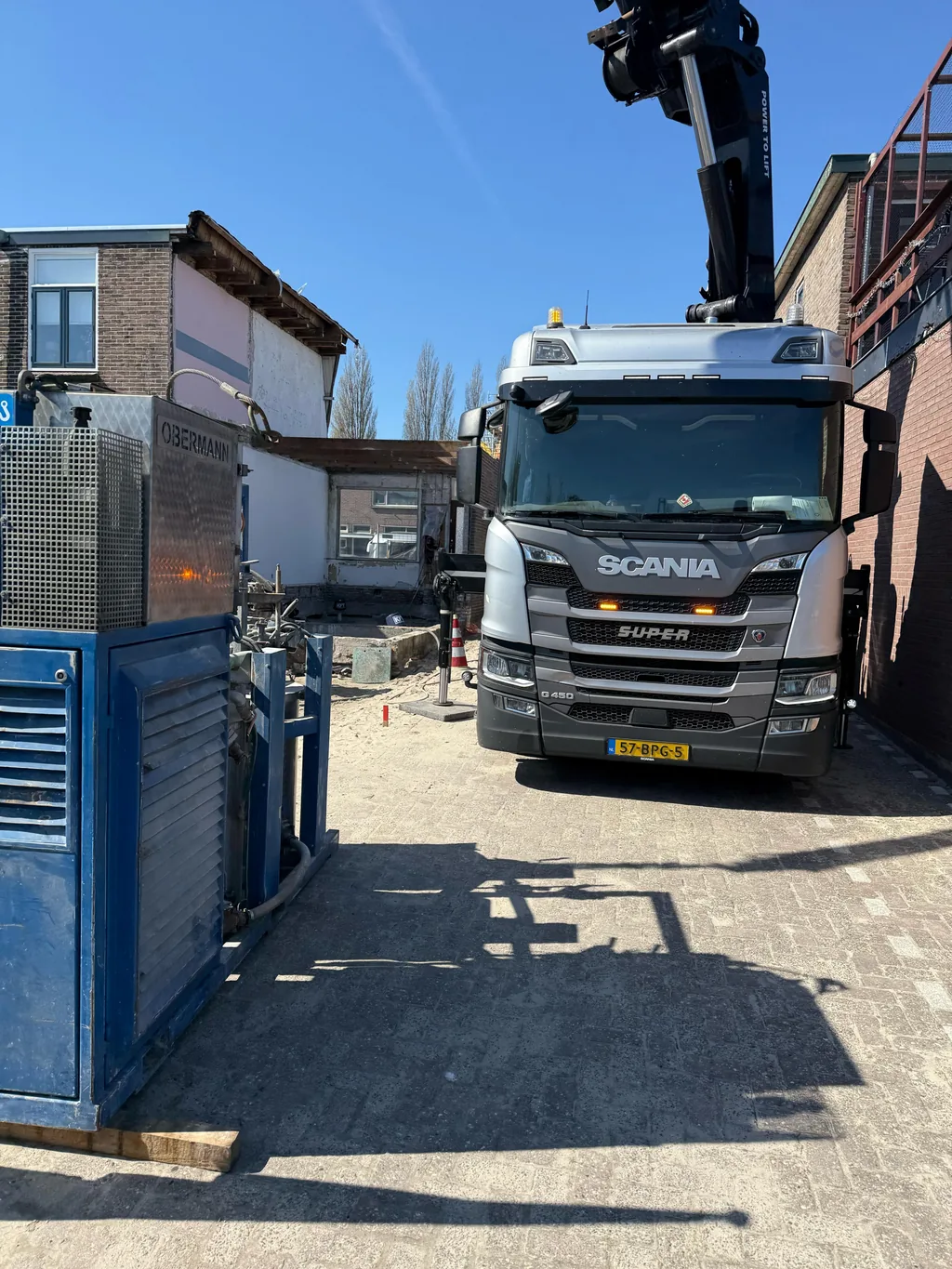Kraanwagen en groutinstallatie opgesteld bij de bouwplaats in Gouda voor funderingsherstel met schroefinjectiepalen