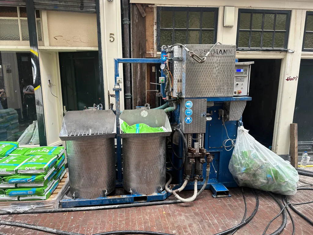Groutinstallatie met zakken bindmiddel op straat bij de Sint Annendwarsstraat in Amsterdam voor het maken van schroefinjectiepalen
