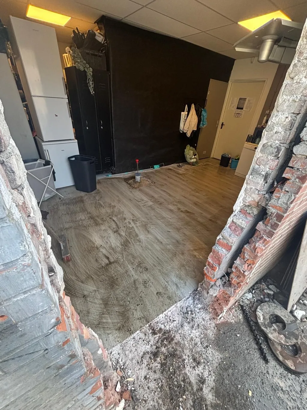 Inpandig aangebrachte schroefinjectiepaal in de vloer van het bestaande pand in Helmond, gezien door de doorbraak in de muur