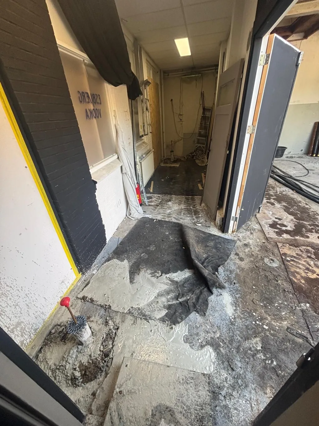 Schroefinjectiepaal inpandig aangebracht in een smalle gang van het pand in Helmond, met grout rond de paalkop
