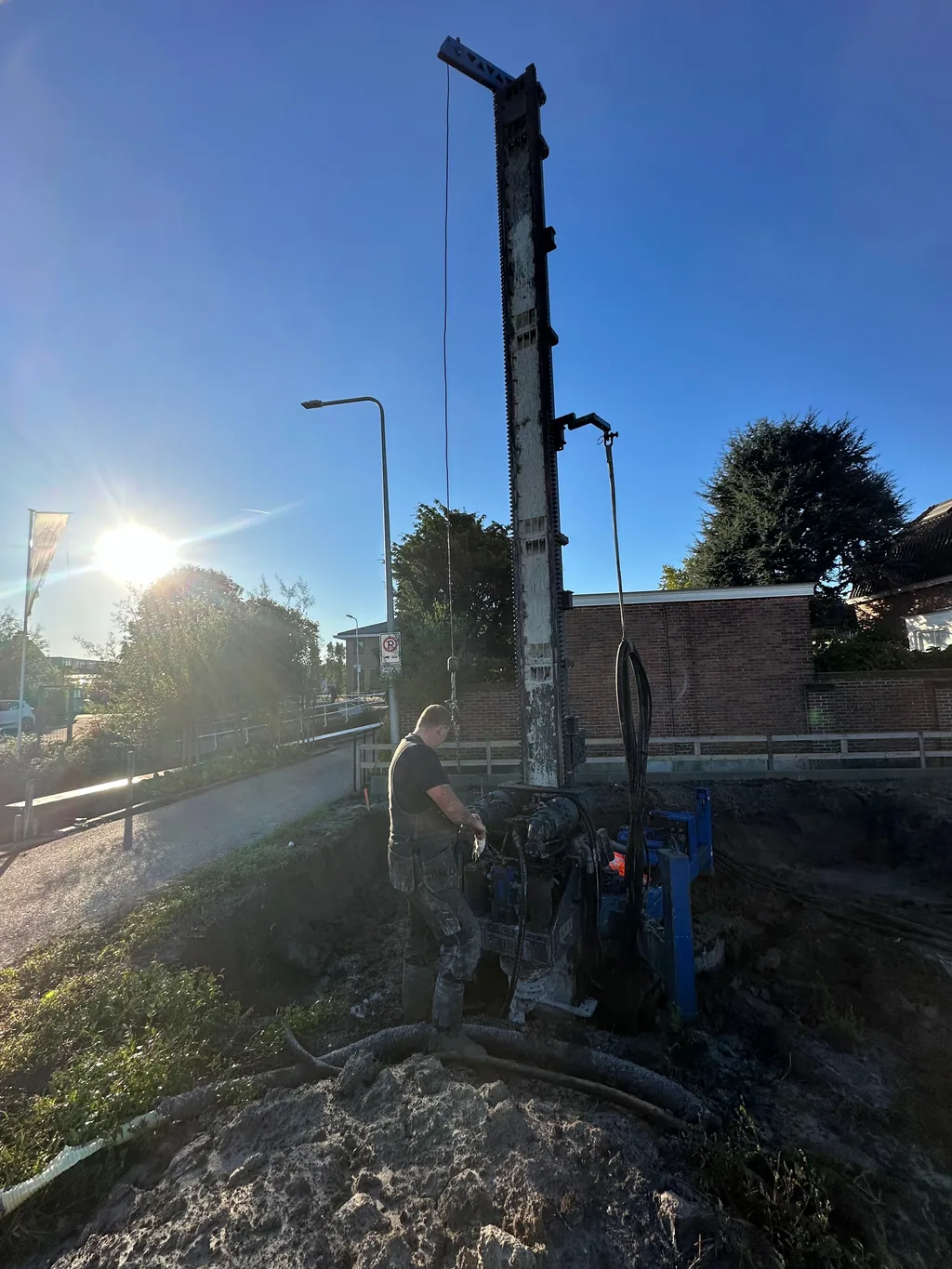 Medewerker bedient de boorstelling bij het plaatsen van schroefinjectiepalen voor een nieuw huis in Honselersdijk