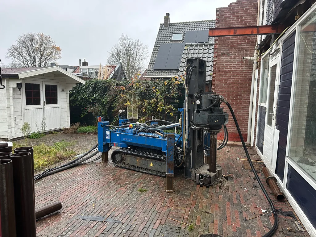 Boorstelling voor schroefinjectiepalen op de bestrating achter een woning aan de Managelaan in Hoofddorp