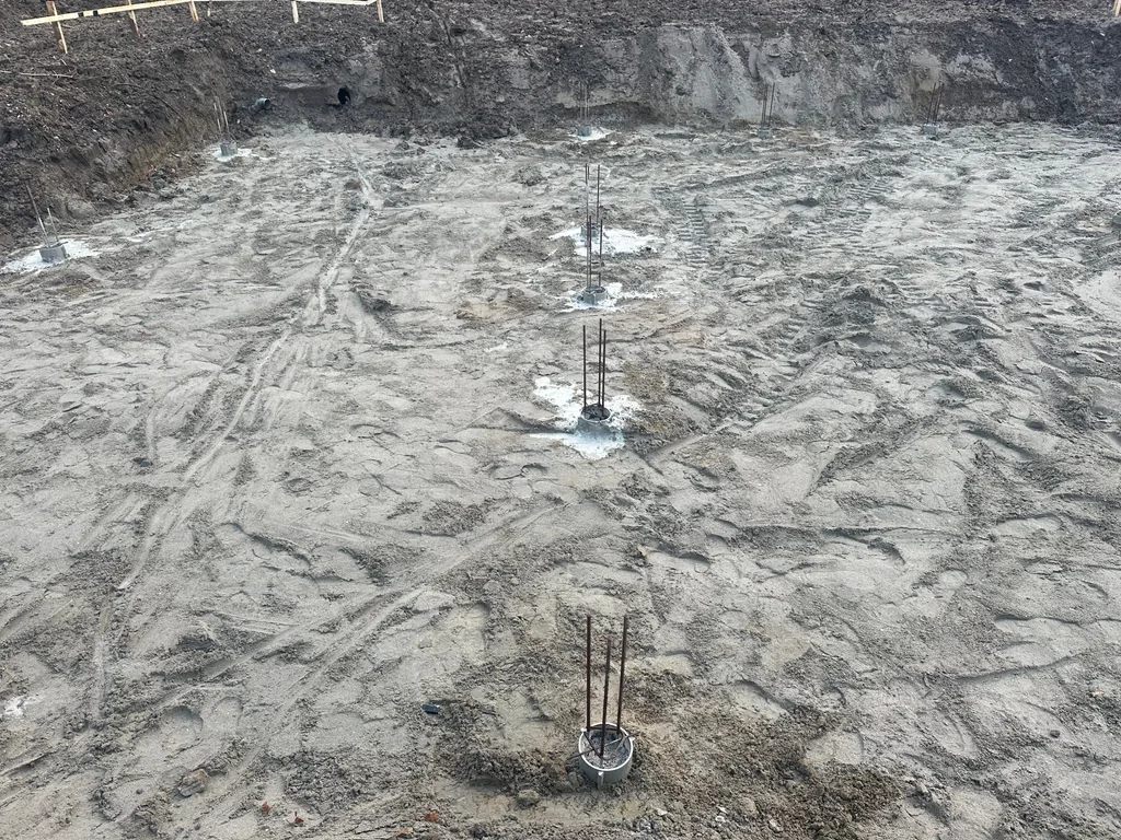 Paalkoppen van schroefinjectiepalen met uitstekende wapening in de zandbodem van de bouwput in Houten