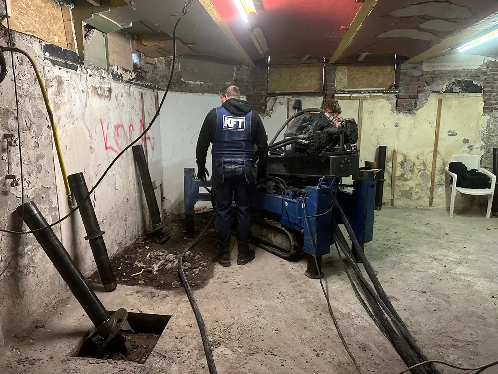 Medewerker van KFT bij een compacte boorstelling voor schroefinjectiepalen in een inpandige ruimte in Zaandam
